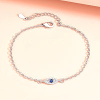 Golden Evil Eye Hand Chain Bracelet with Blue CZ Charm - front view on cream background