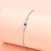 Golden Evil Eye Hand Chain Bracelet with Blue CZ Charm - model wearing - lifestyle styling